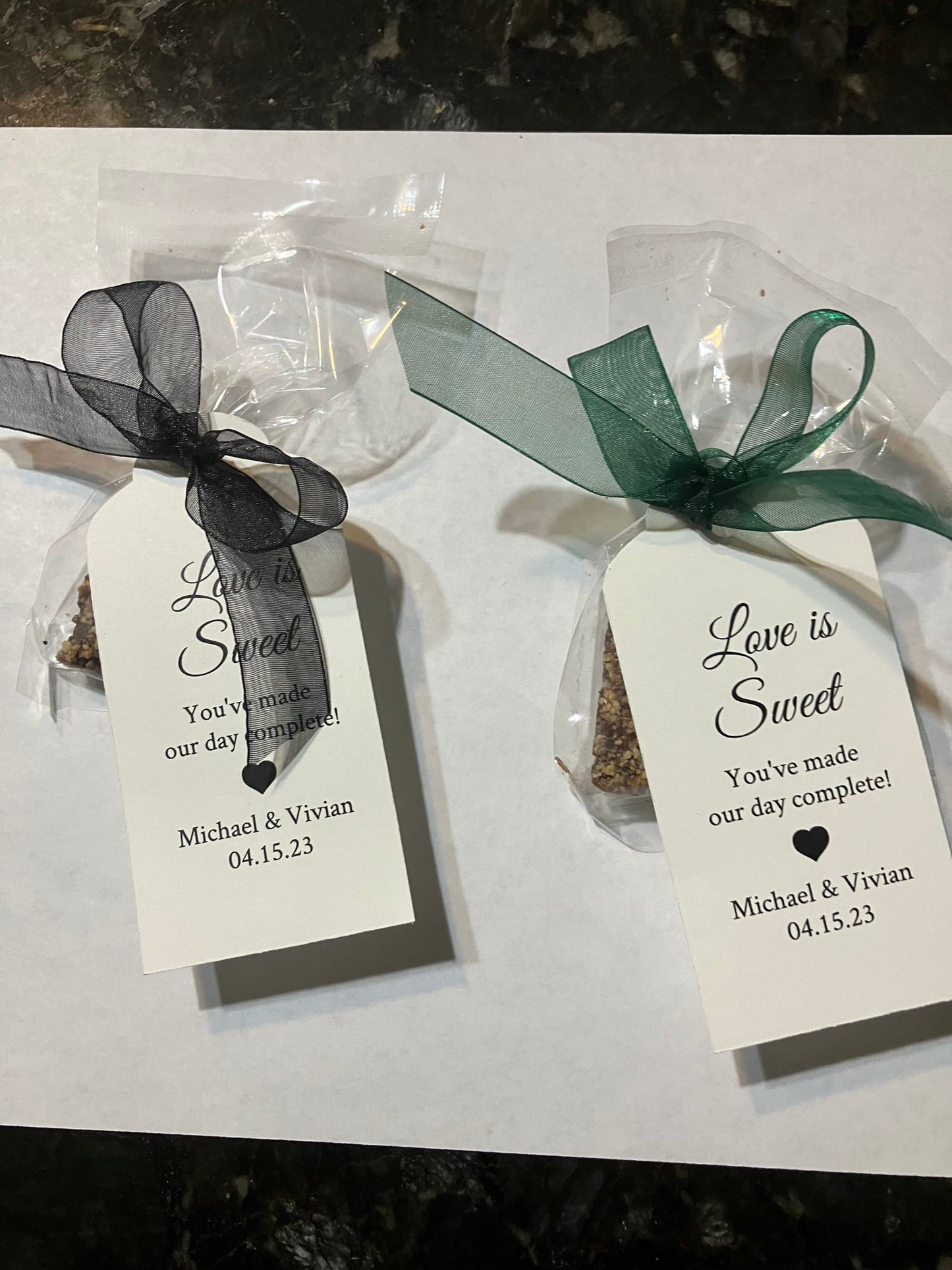 Custom packaged 1 oz candy with black and green ribbon, featuring a white label with text.