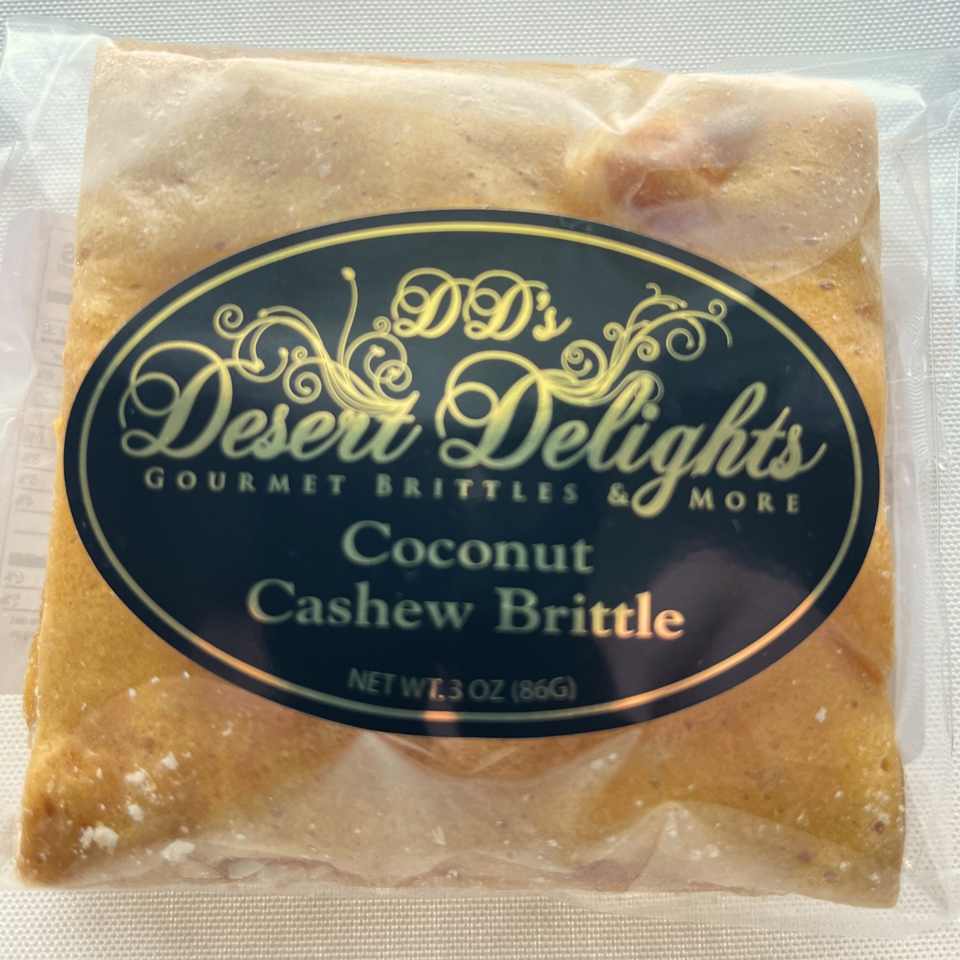 Packaged coconut cashew brittle with 'DD's Desert Delights' label on a white background