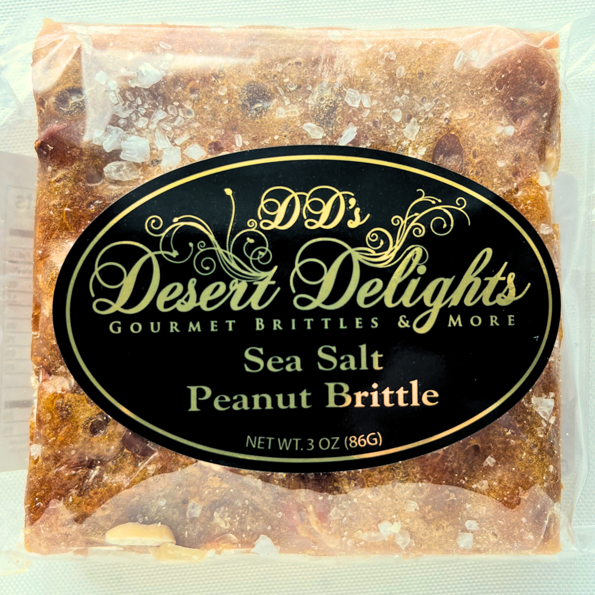 Packaged sea salt peanut brittle with 'DD's Desert Delights' label on a light green background
