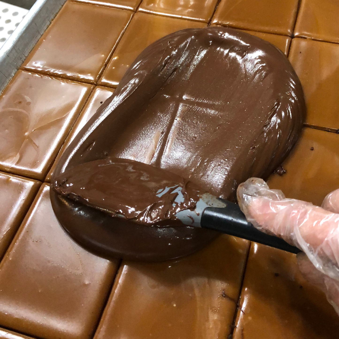 Chocolate being spread onto a surface with a spatula