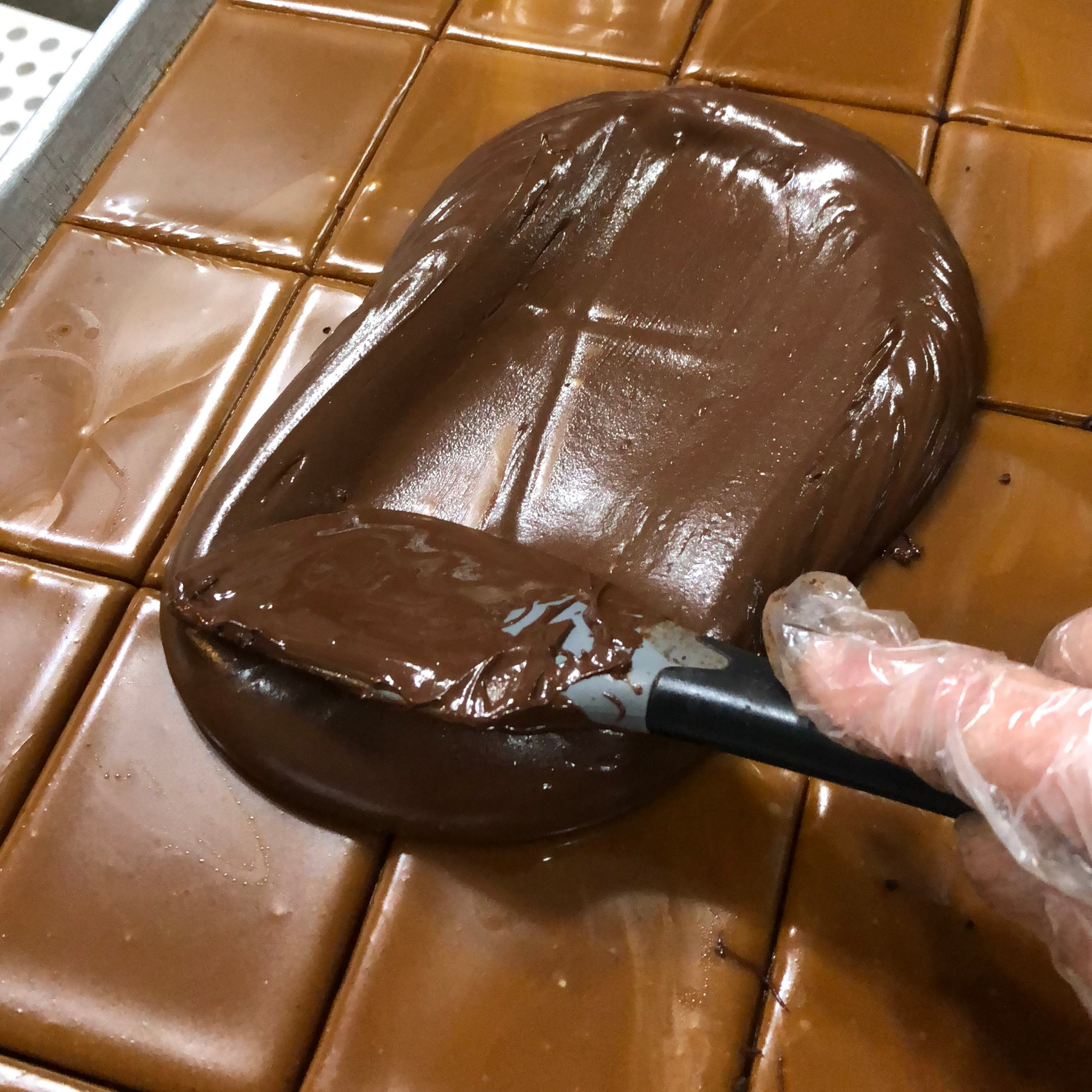 Chocolate being spread onto a surface with a spatula