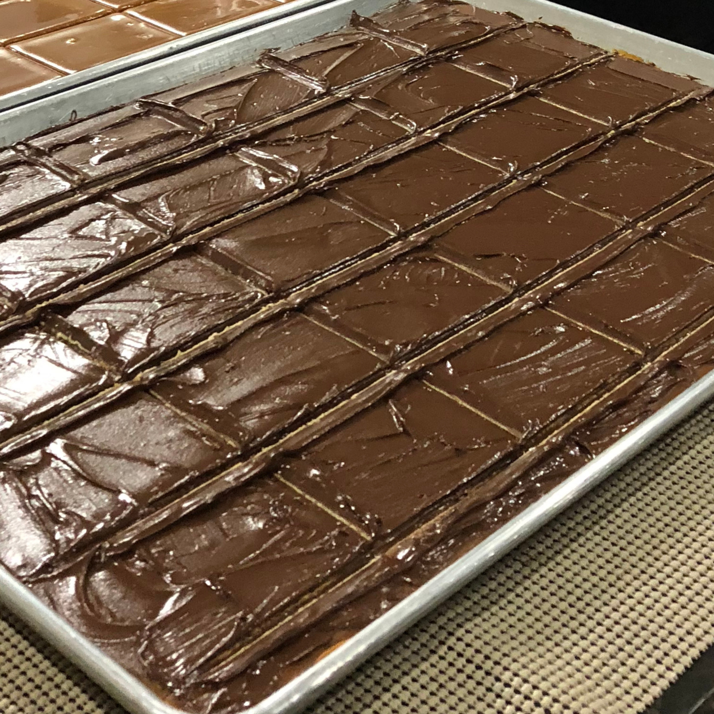 Chocolate frosted toffee on a baking tray
